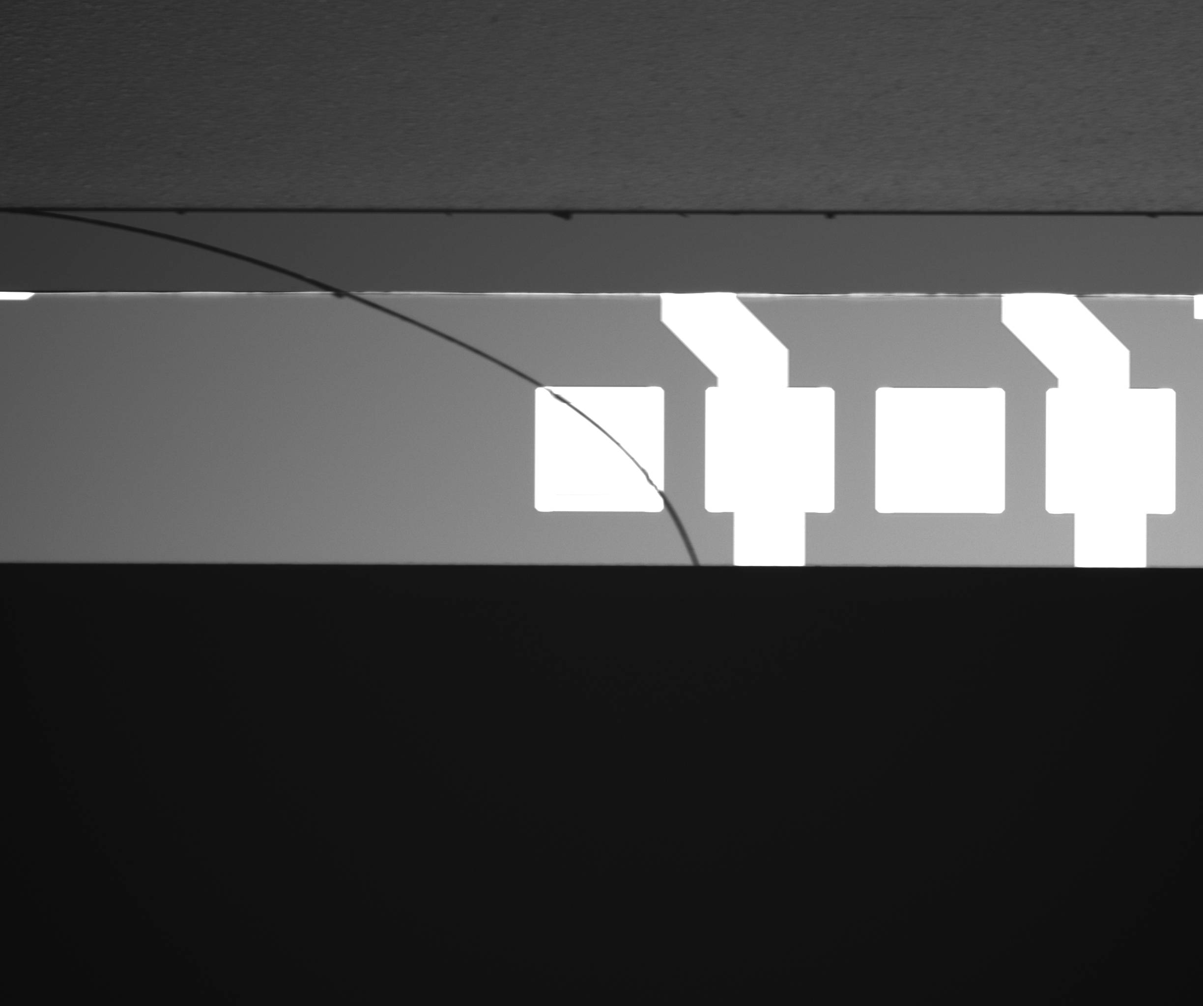 Diagonal crack crossing bright and dark patterned regions
